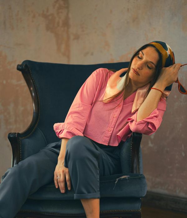 Woman feeling energized and full of life in a bright, soft-toned room.